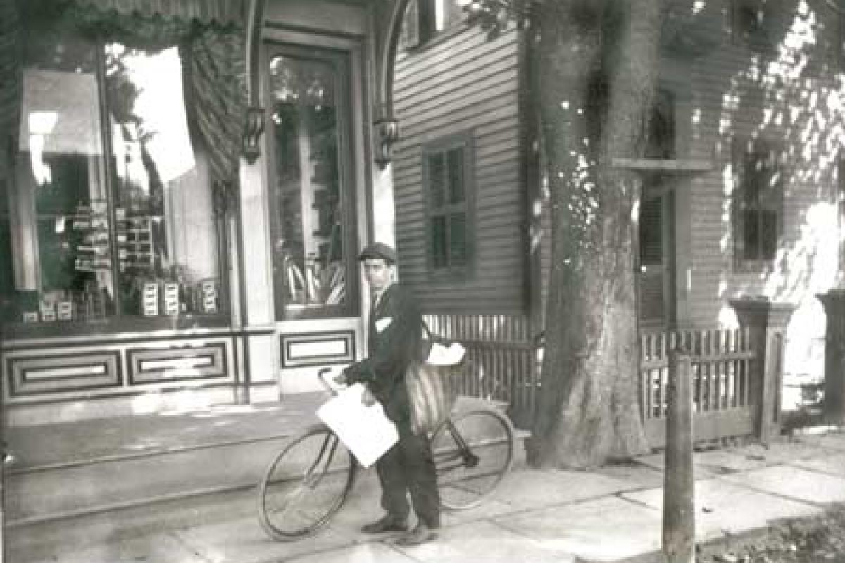 Circa 1900, Jimmy Wallace, paperboy, in front of Mack's Store.